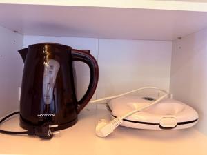 a black tea kettle and a telephone on a counter at LemonTreesHouses 1 Peaceful Stay Near Athens Airport & Rafina Port in Pikérmion