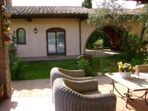 een patio met rieten stoelen en een tafel in de tuin bij La Paloma B&B di Charme in Viterbo
