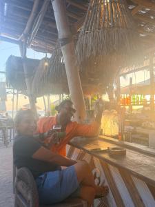 a man and a woman sitting at a bar at My happy place loft gili air in Gili Islands