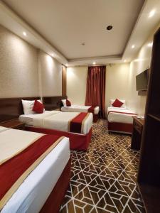 a hotel room with two beds and a television at فندق صفوة المشاعر in Al Khansāk