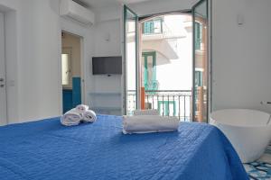 a bedroom with a blue bed with towels on it at Maison Blu Royal in Amalfi