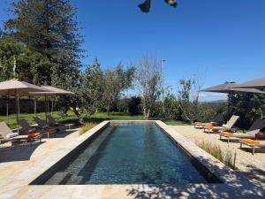 a swimming pool with chairs and umbrellas in a resort at VILLA LORES Adults Only Retreat near Sanxenxo & O Grove in Lores