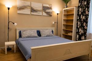 a bedroom with a bed and two lamps and a shelf at Unique Mailo House & Cottage in Riga
