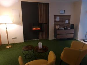 a living room with a couch and a fireplace at Hotel Rheinland in Bad Orb