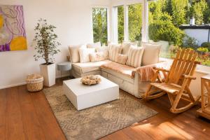 a living room with a couch and a table at Swiss Horizon - Mythenblick - Modern 100m2 mit Alpenblick und Terrassen in Hinwil