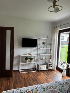 a living room with a television and a white shelf at Prázdninový dům MAJKA in Mosty u Jablunkova +18 photos