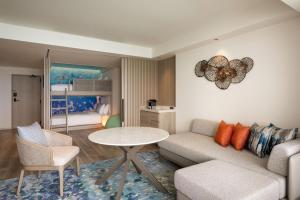 a living room with a couch and a table and a bed at Courtyard by Marriott Okinawa Resort in Nago