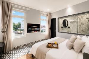 a bedroom with a bed with a tray of food on it at TTR Skypool View Hotel - Đà lạt in Da Lat