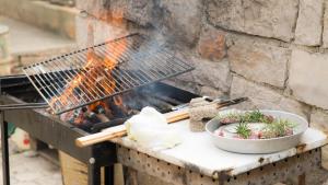 a grill with a bowl of food on it at Robison house Little peace in Vrulje