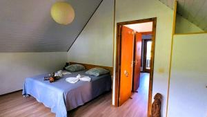 a bedroom with a bed and an open door at Chalet Familiale Vue Mer et Coucher de Soleil Moorea in Moorea