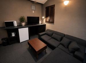 a living room with a couch and a table at ホテルwith宮崎 in Miyazaki