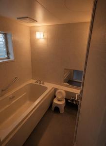 a bathroom with a tub and a toilet and a sink at ホテルwith宮崎 in Miyazaki