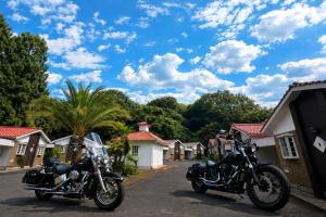 two motorcycles parked in front of a row of houses at ホテルwith宮崎 in Miyazaki