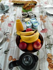 a bowl of fruit with bananas and apples on a table at Karibu Normandy-Maasai in Lisieux