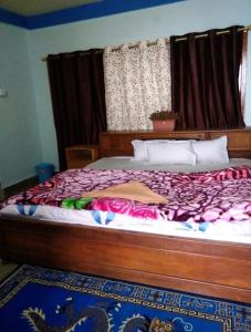 a bedroom with a large bed with a wooden frame at Sunrise hotel Tawang in Tawang