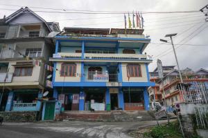 a blue building on the side of a street at Sunrise hotel Tawang in Tawang