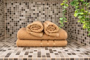 a stack of towels sitting on a tiled floor at Unique Mailo House & Cottage in Riga
