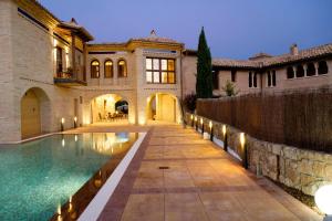 an exterior view of a house with a swimming pool at Hotel Villa de Alquézar in Alquézar