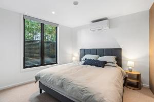 a bedroom with a large bed and a large window at Brighton Beach Terrace in Melbourne