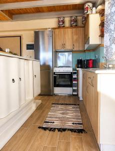 a kitchen with stainless steel appliances and wooden cabinets at EuZoea Country Home 1 Nature Escape with Pool in Kapandrítion +29 photos