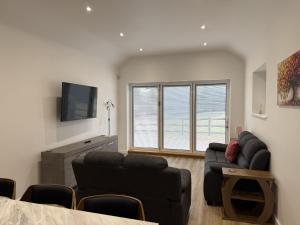 a living room with a couch and a tv at Crossways Sycamore in Grimsby