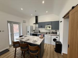 a kitchen with a table and some chairs in it at Crossways Sycamore in Grimsby +51 photos