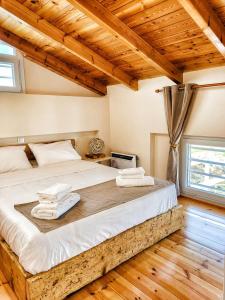 a bedroom with a large bed with wooden ceilings at EuZoea Country Home 1 Nature Escape with Pool in Kapandrítion