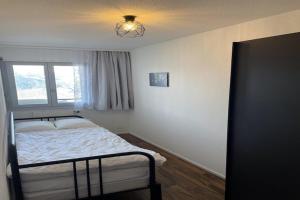 a bedroom with a bed and a window at Charming apartment with hill view in Veysonnaz