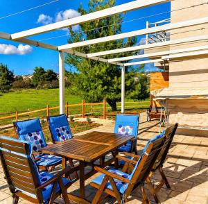 a wooden table and chairs on a patio at EuZoea Country Home 1 Nature Escape with Pool in Kapandrítion