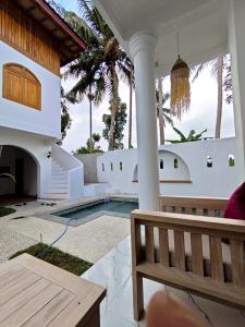 a porch with a bench and a swimming pool at Tetebatu Sunset House in Tetebatu