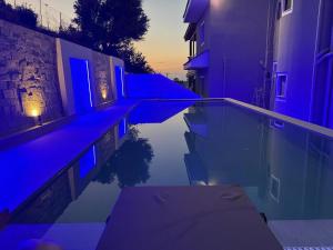 a night view of a swimming pool with purple lights at Erato Superior Suite in Kremasti