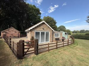 a wooden fence in front of a tiny house at Crossways Sycamore in Grimsby