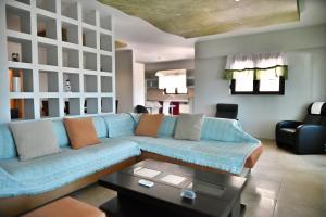 a living room with a blue couch and a table at Erato Superior Suite in Kremasti