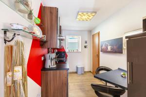 a small kitchen with a table and a red wall at Ferienwohnung Elbtalblick in Weinböhla