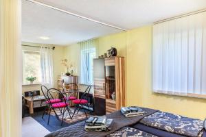 a bedroom with a bed and a dining room at Ferienwohnung Elbtalblick in Weinböhla +17 photos