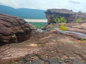a group of large rocks with a body of water at S&A Camping in Ban Kum