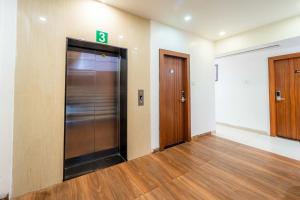 an elevator in an empty room with two doors at Treebo Ten Eleven Grand, Scheme 78 in Indore