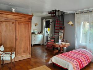 a bedroom with a bed and a table and a staircase at Karibu Normandy in Saint-Désir +7 photos
