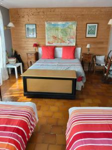a bedroom with a bed with red pillows at Karibu Normandy in Saint-Désir
