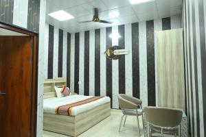 a bedroom with a bed and a table and chairs at Mansa Lawn & Resort in Lucknow