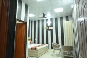 a bedroom with a bed and a table and chairs at Mansa Lawn & Resort in Lucknow