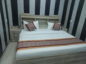a bedroom with a bed with pillows on it at Mansa Lawn & Resort in Lucknow