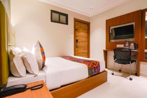 a bedroom with a bed and a desk with a computer at FabHotel Ruby Grand in Mumbai