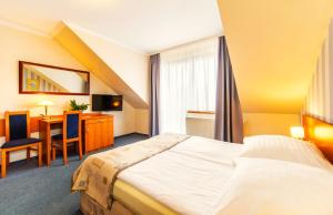 a hotel room with a bed and a table at Astra Dziwnówek Dom Gościnny in Dziwnówek