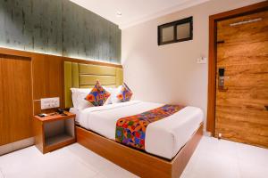 a bedroom with a bed and a wooden door at FabHotel Ruby Grand in Mumbai