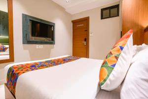 a bedroom with a bed and a tv on the wall at FabHotel Ruby Grand in Mumbai