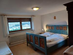 a bedroom with a blue bed and a window at Ferienwohnung Maria & Luis in Kolsass