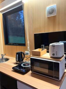a microwave sitting on top of a kitchen counter at Gum Tree by Tiny Away in Dixons Creek
