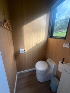 a bathroom with a toilet and a window at Gum Tree by Tiny Away in Dixons Creek +11 photos