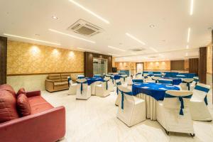 a banquet hall with blue tables and white chairs at Treebo Ten Eleven Grand, Scheme 78 in Indore